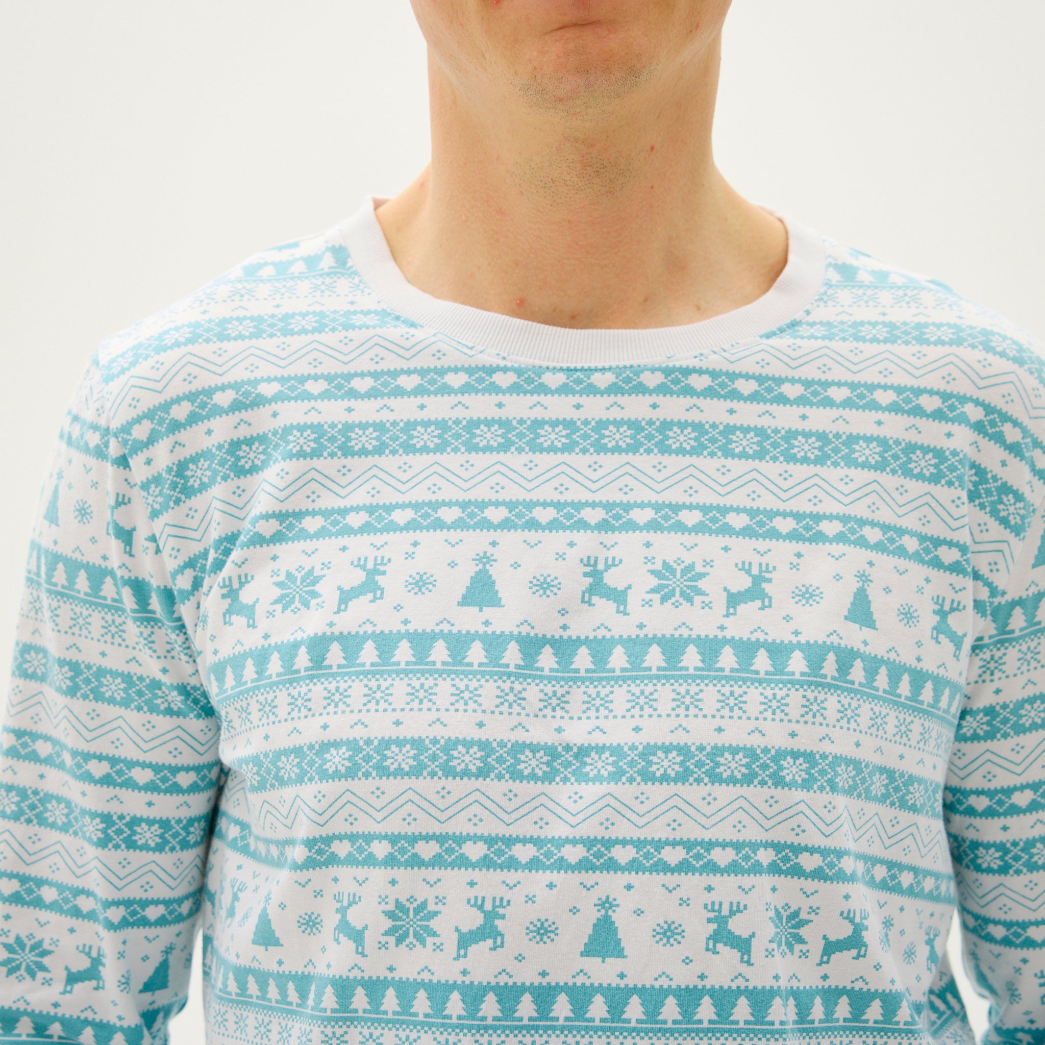 Ein springender Mann in einem hellblauen Weihnachtspyjama.